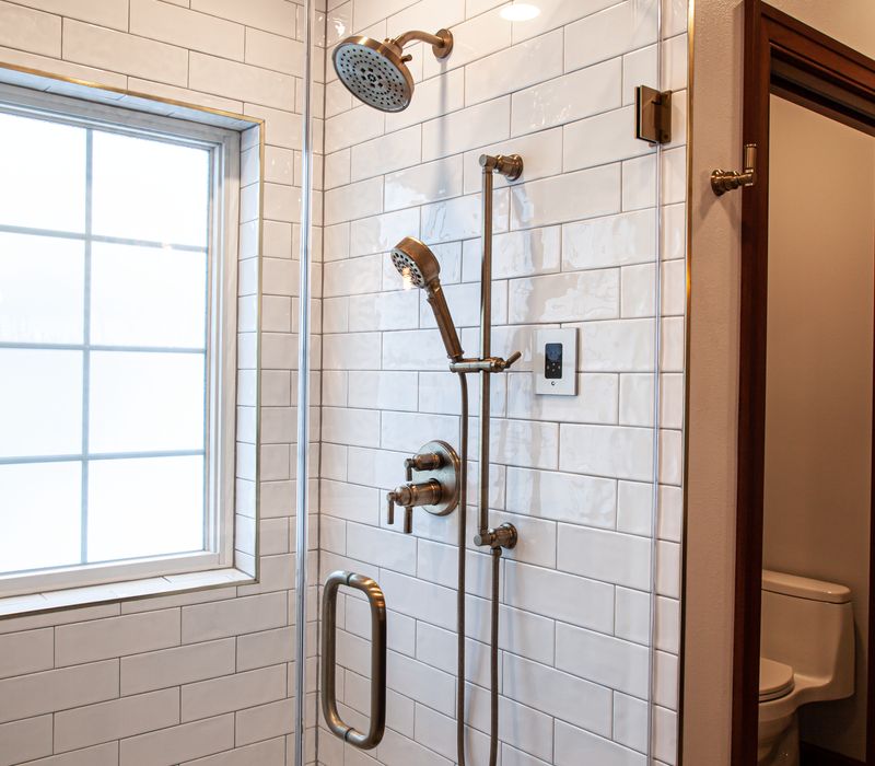 Black and white encaustic tiles, gold-rimmed arch mirrors, and dark cabinetry give old world charm to this sumptuous bathroom.
