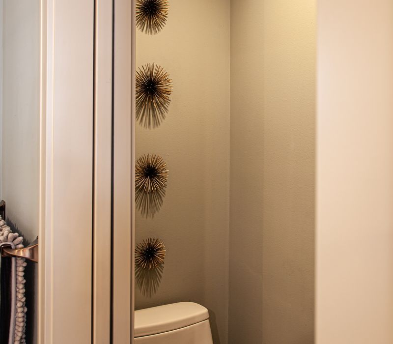 Bronze crosshatched mirror frames, herringbone wood look floor tile, and a vaulted ceiling add distinction to this two vanity bathroom.