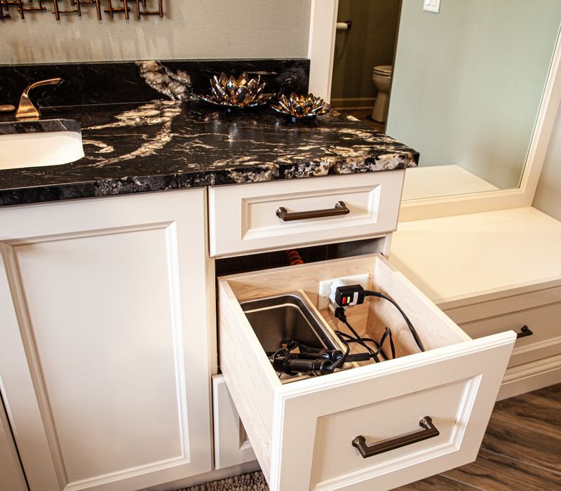 Bronze crosshatched mirror frames, herringbone wood look floor tile, and a vaulted ceiling add distinction to this two vanity bathroom.