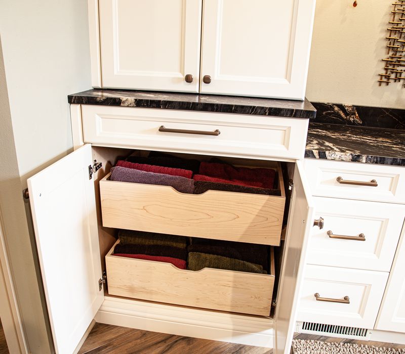 Bronze crosshatched mirror frames, herringbone wood look floor tile, and a vaulted ceiling add distinction to this two vanity bathroom.