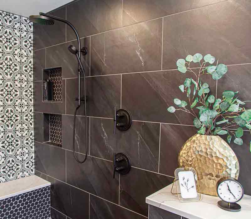 Elegance reigns supreme in this bathroom remodel that features an en suite, walk-in closet, walk-in shower, custom double vanity, private water closet, framed-glass barn doors, and a dazzling starburst chandelier.