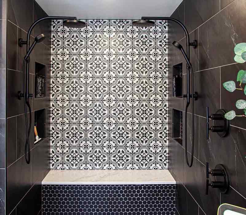 Elegance reigns supreme in this bathroom remodel that features an en suite, walk-in closet, walk-in shower, custom double vanity, private water closet, framed-glass barn doors, and a dazzling starburst chandelier.