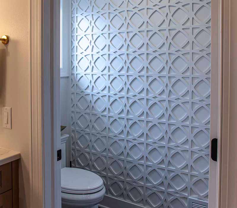 Elegance reigns supreme in this bathroom remodel that features an en suite, walk-in closet, walk-in shower, custom double vanity, private water closet, framed-glass barn doors, and a dazzling starburst chandelier.