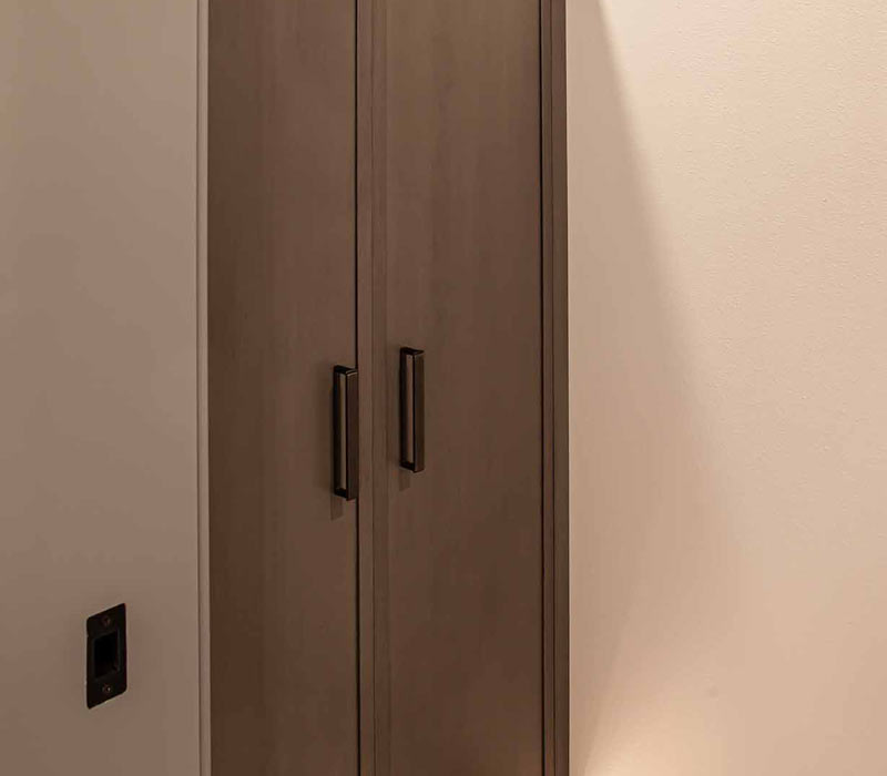 This bathroom features a freestanding tub in an alcove, set off by a dark accent wall with two modern sconces and a glass shower stall with a marble wall.
