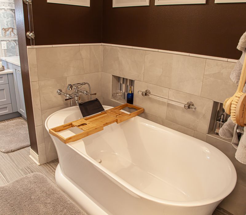 Wallpaper featuring monkeys posing on Venetian architecture, light blue cabinets, and elongated hexagon mosaic tiles add interest to this elegant bathroom with laundry machines and an attached walk-in closet.