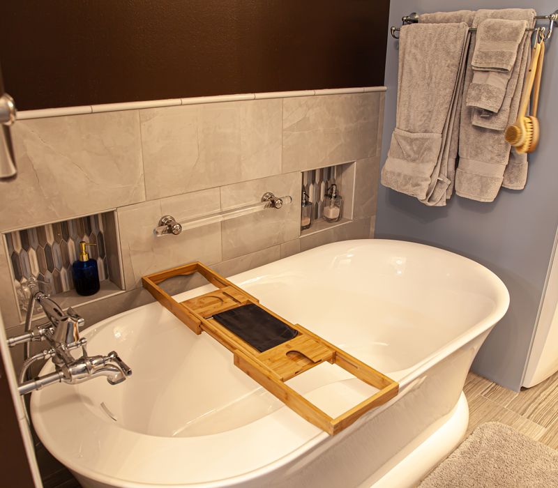 Wallpaper featuring monkeys posing on Venetian architecture, light blue cabinets, and elongated hexagon mosaic tiles add interest to this elegant bathroom with laundry machines and an attached walk-in closet.