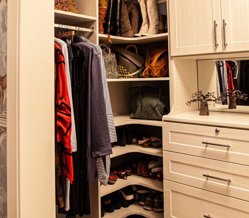 Wallpaper featuring monkeys posing on Venetian architecture, light blue cabinets, and elongated hexagon mosaic tiles add interest to this elegant bathroom with laundry machines and an attached walk-in closet.