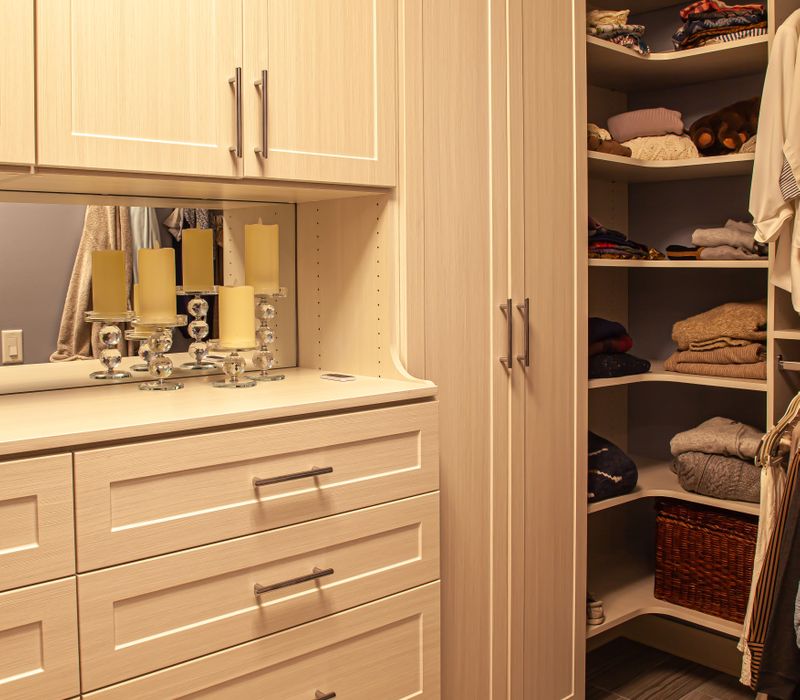 Wallpaper featuring monkeys posing on Venetian architecture, light blue cabinets, and elongated hexagon mosaic tiles add interest to this elegant bathroom with laundry machines and an attached walk-in closet.