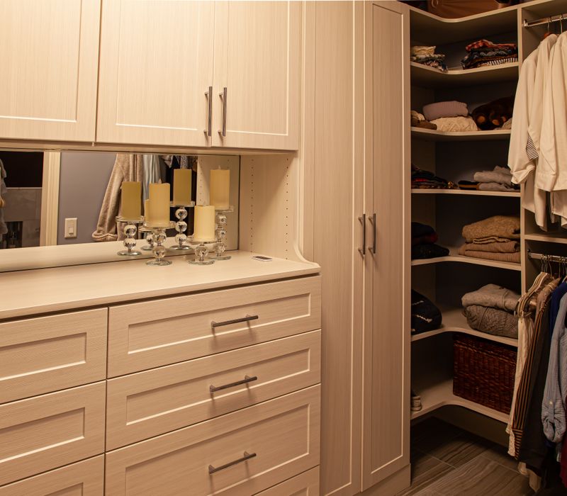 Wallpaper featuring monkeys posing on Venetian architecture, light blue cabinets, and elongated hexagon mosaic tiles add interest to this elegant bathroom with laundry machines and an attached walk-in closet.