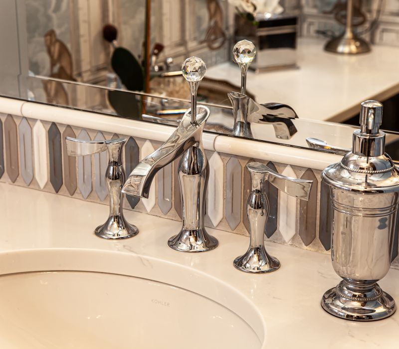 Wallpaper featuring monkeys posing on Venetian architecture, light blue cabinets, and elongated hexagon mosaic tiles add interest to this elegant bathroom with laundry machines and an attached walk-in closet.