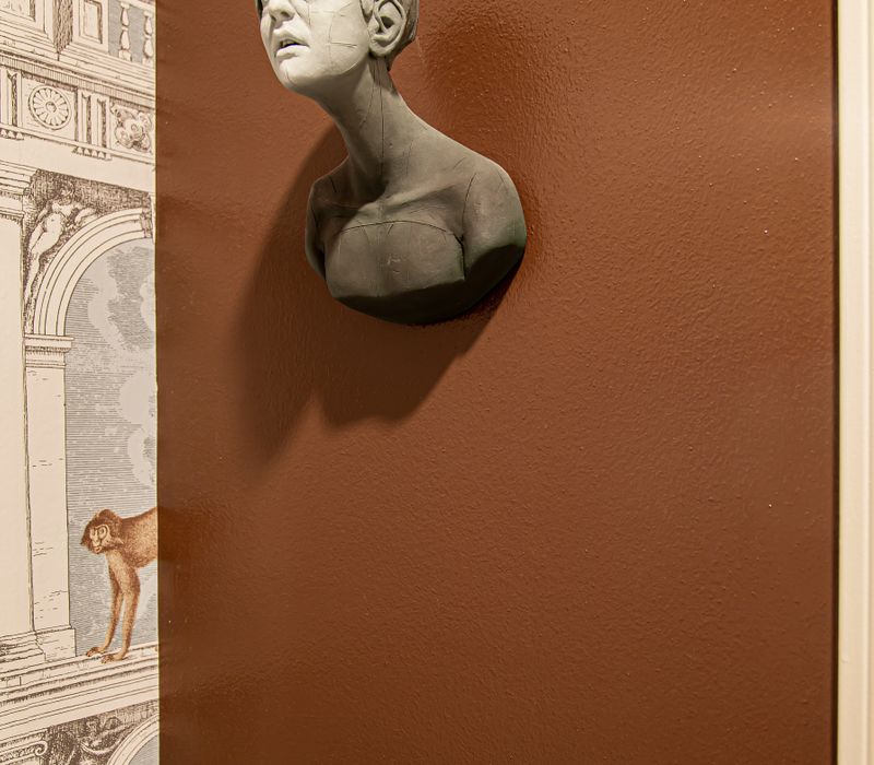 Wallpaper featuring monkeys posing on Venetian architecture, light blue cabinets, and elongated hexagon mosaic tiles add interest to this elegant bathroom with laundry machines and an attached walk-in closet.