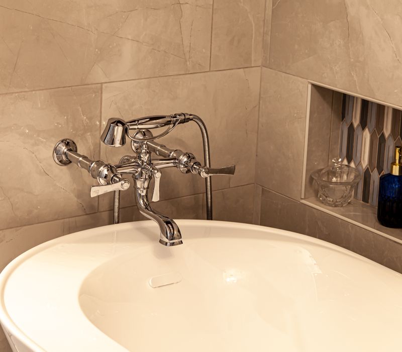 Wallpaper featuring monkeys posing on Venetian architecture, light blue cabinets, and elongated hexagon mosaic tiles add interest to this elegant bathroom with laundry machines and an attached walk-in closet.