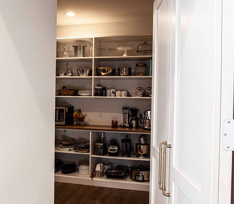 Concealed by what looks like tall cabinet doors, this full walk-in pantry frees up space in the kitchen and provides convenient storage for dry goods, perishables, and cookware alike.