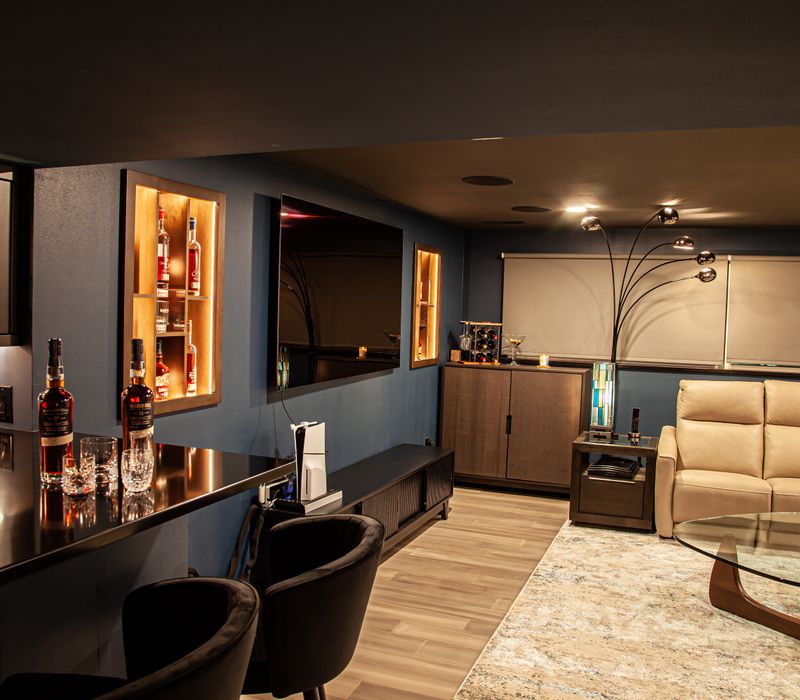 These dramatic lighted cabinets showcase an extensive liquor collection, while the bar provides a convenient spot to enjoy it, and the basement rec room a place to unwind.