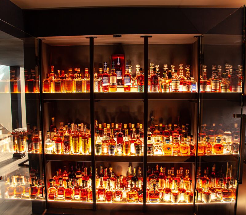 These dramatic lighted cabinets showcase an extensive liquor collection, while the bar provides a convenient spot to enjoy it, and the basement rec room a place to unwind.