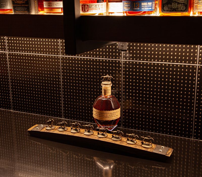 These dramatic lighted cabinets showcase an extensive liquor collection, while the bar provides a convenient spot to enjoy it, and the basement rec room a place to unwind.