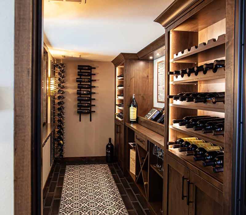 This wine cellar features a wine room with temperature and humidity control and custom storage and displays for up to 350 bottles. The adjoining wine tasting room provides space for the homeowners to gather, converse, and celebrate.