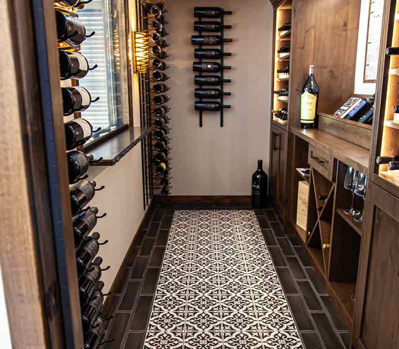 This wine cellar features a wine room with temperature and humidity control and custom storage and displays for up to 350 bottles. The adjoining wine tasting room provides space for the homeowners to gather, converse, and celebrate.