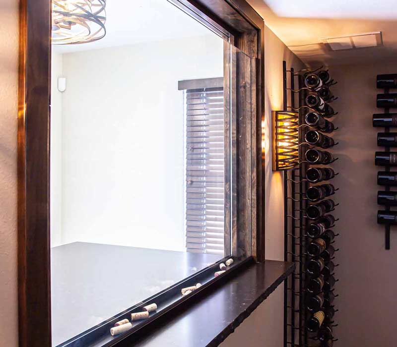 This wine cellar features a wine room with temperature and humidity control and custom storage and displays for up to 350 bottles. The adjoining wine tasting room provides space for the homeowners to gather, converse, and celebrate.