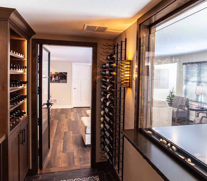 This wine cellar features a wine room with temperature and humidity control and custom storage and displays for up to 350 bottles. The adjoining wine tasting room provides space for the homeowners to gather, converse, and celebrate.