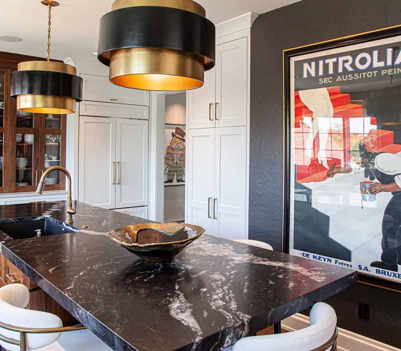 This complete kitchen remodel utilizes timeless materials, an intelligent reconfiguration of the space, and an effortless blend of natural light and warmth. It features cabinetry by DHDK, black quartzite countertops, herringbone wood flooring, a Broan pop-up downdraft hood, and a wet bar.