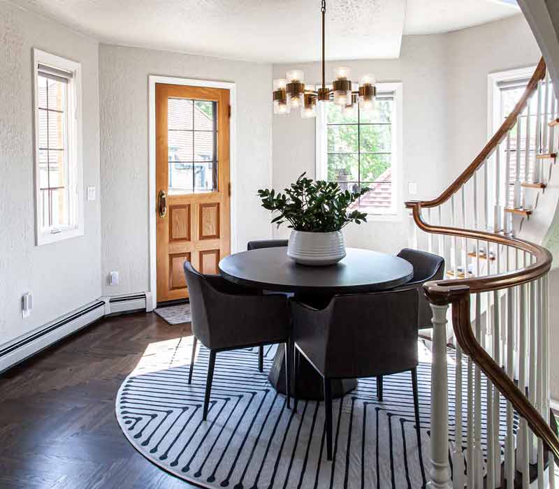 This complete kitchen remodel utilizes timeless materials, an intelligent reconfiguration of the space, and an effortless blend of natural light and warmth. It features cabinetry by DHDK, black quartzite countertops, herringbone wood flooring, a Broan pop-up downdraft hood, and a wet bar.