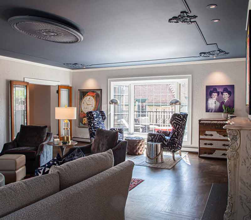 This complete kitchen remodel utilizes timeless materials, an intelligent reconfiguration of the space, and an effortless blend of natural light and warmth. It features cabinetry by DHDK, black quartzite countertops, herringbone wood flooring, a Broan pop-up downdraft hood, and a wet bar.