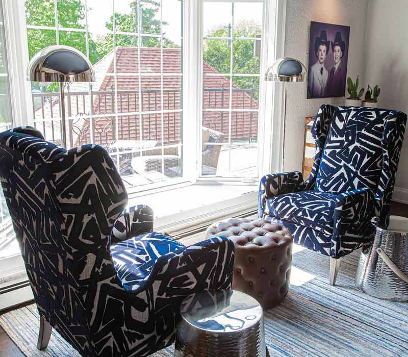This complete kitchen remodel utilizes timeless materials, an intelligent reconfiguration of the space, and an effortless blend of natural light and warmth. It features cabinetry by DHDK, black quartzite countertops, herringbone wood flooring, a Broan pop-up downdraft hood, and a wet bar.