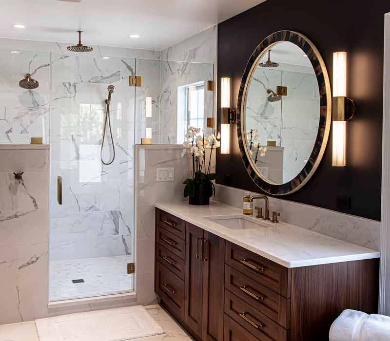 This complete kitchen remodel utilizes timeless materials, an intelligent reconfiguration of the space, and an effortless blend of natural light and warmth. It features cabinetry by DHDK, black quartzite countertops, herringbone wood flooring, a Broan pop-up downdraft hood, and a wet bar.