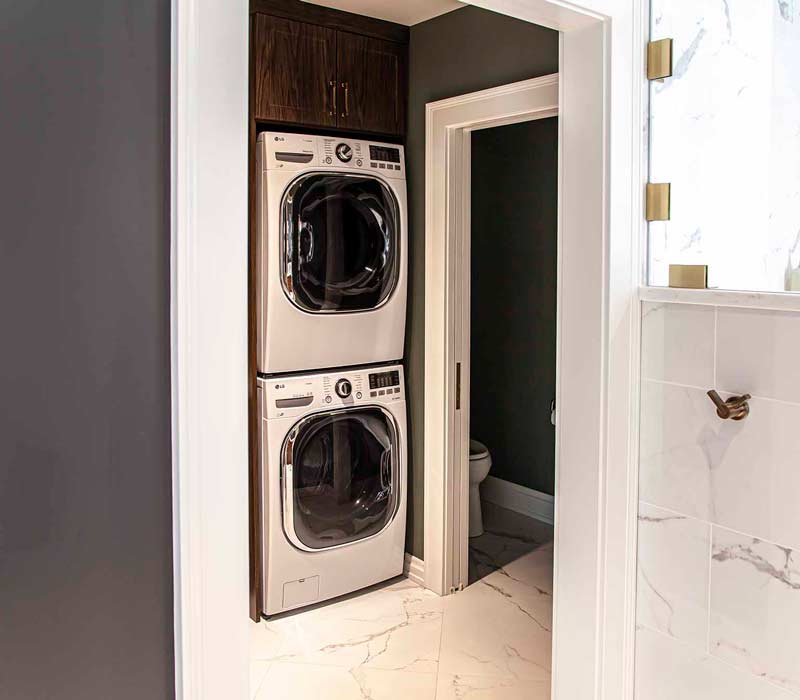 This complete kitchen remodel utilizes timeless materials, an intelligent reconfiguration of the space, and an effortless blend of natural light and warmth. It features cabinetry by DHDK, black quartzite countertops, herringbone wood flooring, a Broan pop-up downdraft hood, and a wet bar.