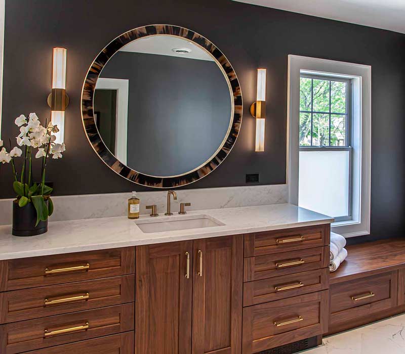 This complete kitchen remodel utilizes timeless materials, an intelligent reconfiguration of the space, and an effortless blend of natural light and warmth. It features cabinetry by DHDK, black quartzite countertops, herringbone wood flooring, a Broan pop-up downdraft hood, and a wet bar.