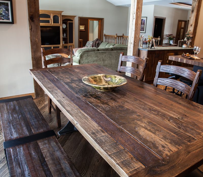 Rustic brick walls, rough-hewn beams, an end-grain cutting board, and a hammered copper sink and range hood add texture to this woodsy open concept kitchen.