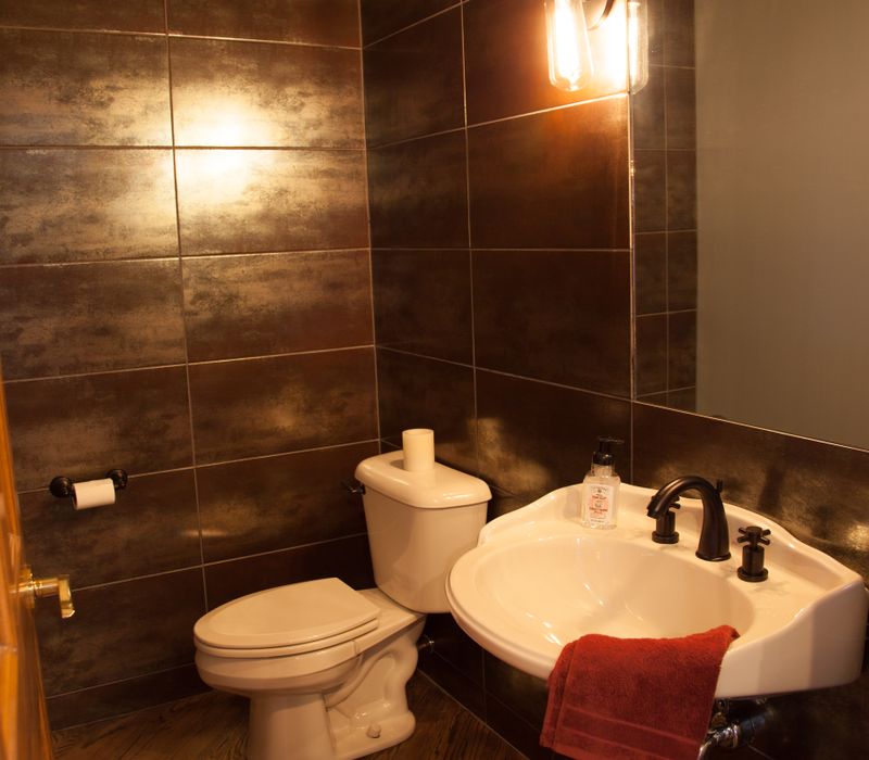 Rustic brick walls, rough-hewn beams, an end-grain cutting board, and a hammered copper sink and range hood add texture to this woodsy open concept kitchen.