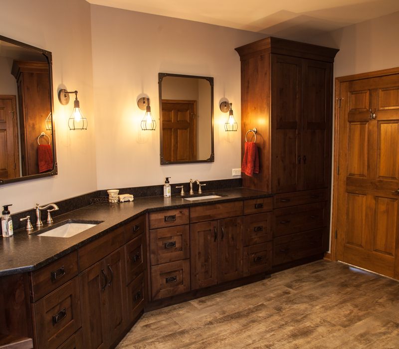 Rustic brick walls, rough-hewn beams, an end-grain cutting board, and a hammered copper sink and range hood add texture to this woodsy open concept kitchen.