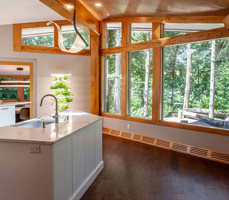 This kitchen remodel celebrates family, nature, and the unique geometry of the original home. It features crisp white cabinetry, cool-toned quartz countertops, two islands, and bold blue accents, plus a tactile mix of materials—wood, metal, glass, and stone—selected to stand the test of time in both durability and style.