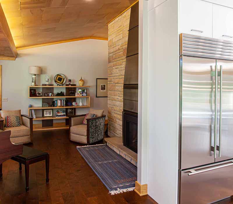 This kitchen remodel celebrates family, nature, and the unique geometry of the original home. It features crisp white cabinetry, cool-toned quartz countertops, two islands, and bold blue accents, plus a tactile mix of materials—wood, metal, glass, and stone—selected to stand the test of time in both durability and style.
