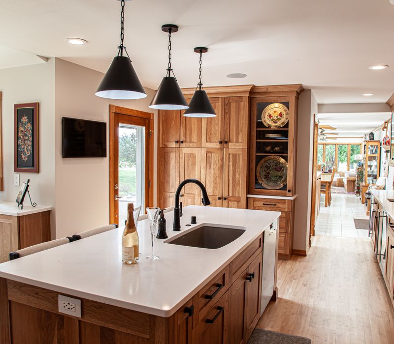Contemporary black and white geometric accents play off the warm traditional wood cabinetry of this sophisticated kitchen.