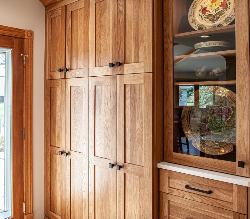 Contemporary black and white geometric accents play off the warm traditional wood cabinetry of this sophisticated kitchen.