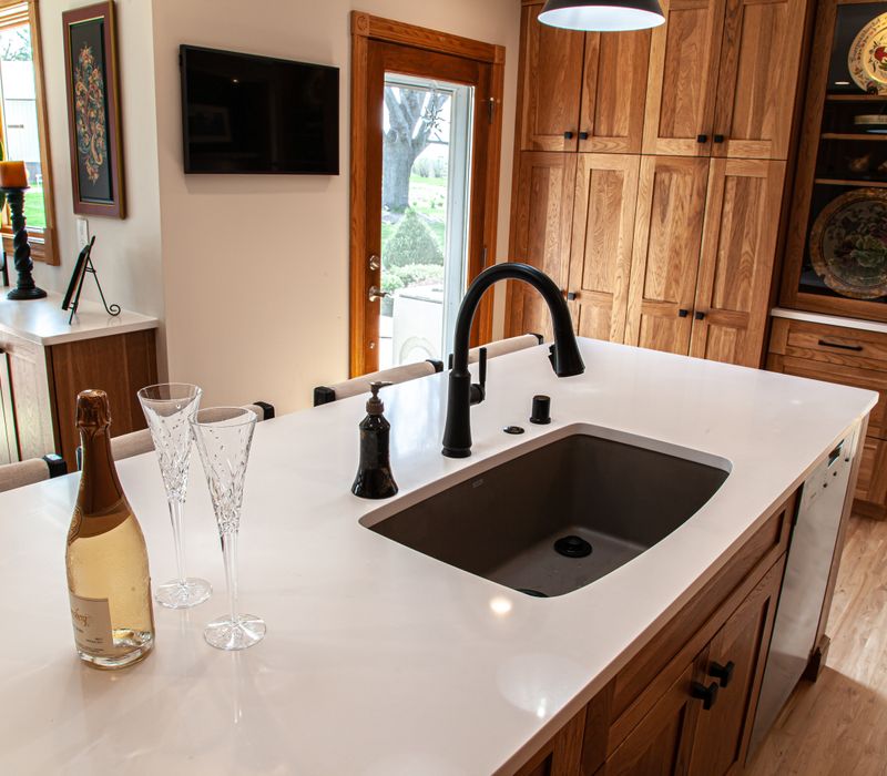 Contemporary black and white geometric accents play off the warm traditional wood cabinetry of this sophisticated kitchen.