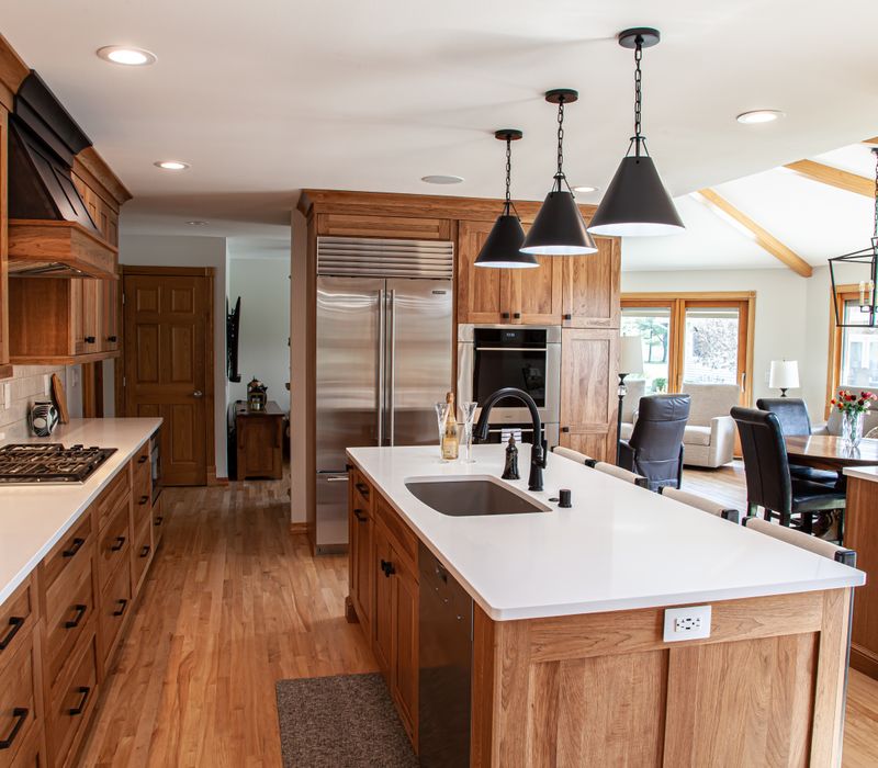 Contemporary black and white geometric accents play off the warm traditional wood cabinetry of this sophisticated kitchen.