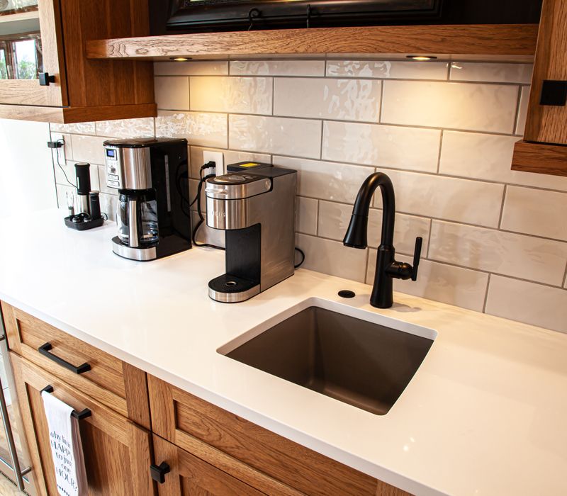 Contemporary black and white geometric accents play off the warm traditional wood cabinetry of this sophisticated kitchen.