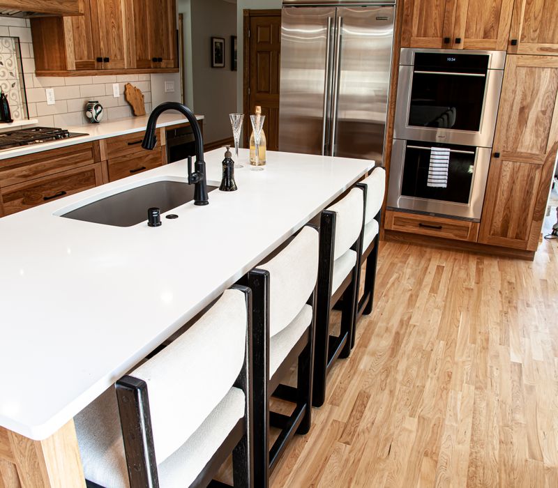 Contemporary black and white geometric accents play off the warm traditional wood cabinetry of this sophisticated kitchen.