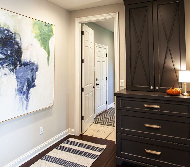 This light-filled, European inspired kitchen includes a bay windowed breakfast nook and opens onto an expansive deck. The striking black cabinetry coordinates with the black and brass pendant lamps and range hood.