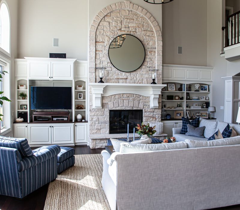 This light-filled, European inspired kitchen includes a bay windowed breakfast nook and opens onto an expansive deck. The striking black cabinetry coordinates with the black and brass pendant lamps and range hood.