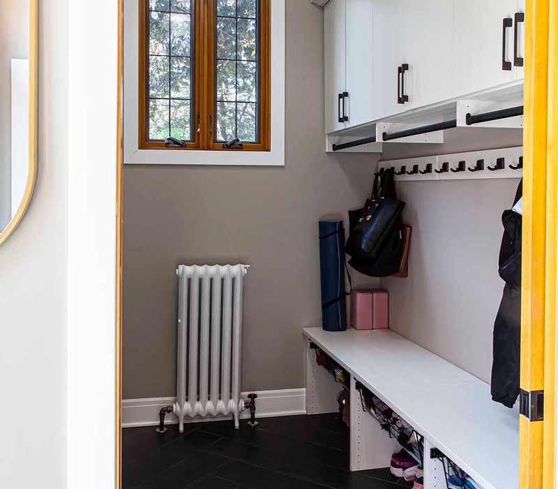 A kitchen featuring end-grain countertop, hardwood floors, and white glass tiles opens out onto a spacious deck in this Tudor style house.