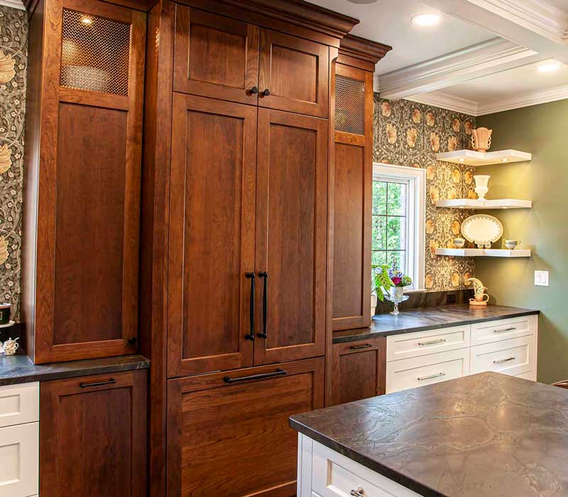 A chrome pull-down wheel faucet is the centerpiece of this traditional kitchen with natural slate countertops, art nouveau floral wallpaper, and green walls.