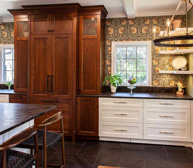 A chrome pull-down wheel faucet is the centerpiece of this traditional kitchen with natural slate countertops, art nouveau floral wallpaper, and green walls.