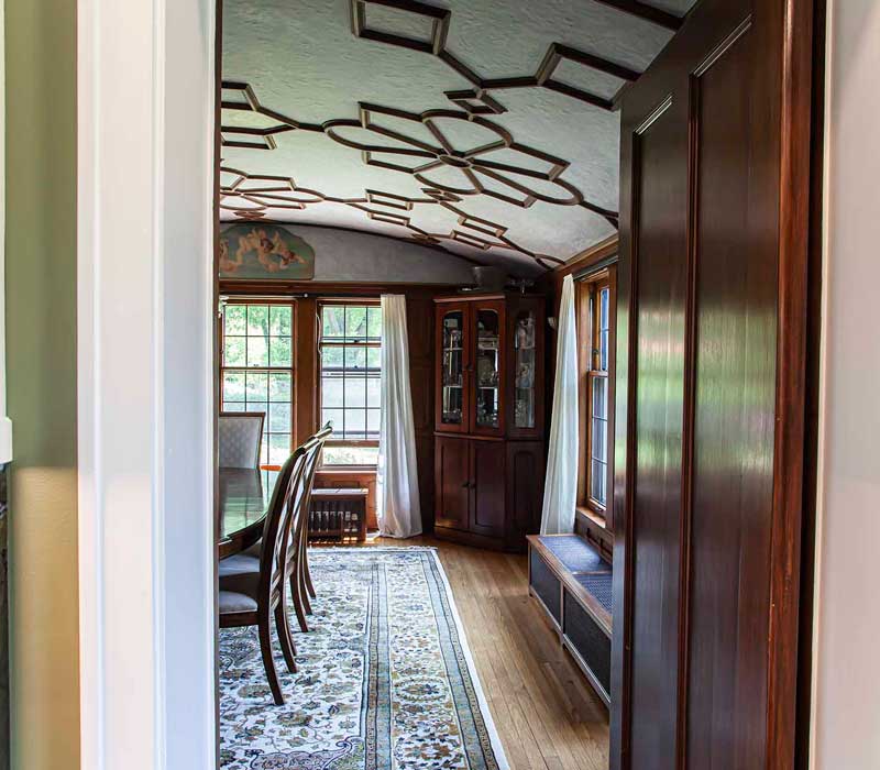 A chrome pull-down wheel faucet is the centerpiece of this traditional kitchen with natural slate countertops, art nouveau floral wallpaper, and green walls.