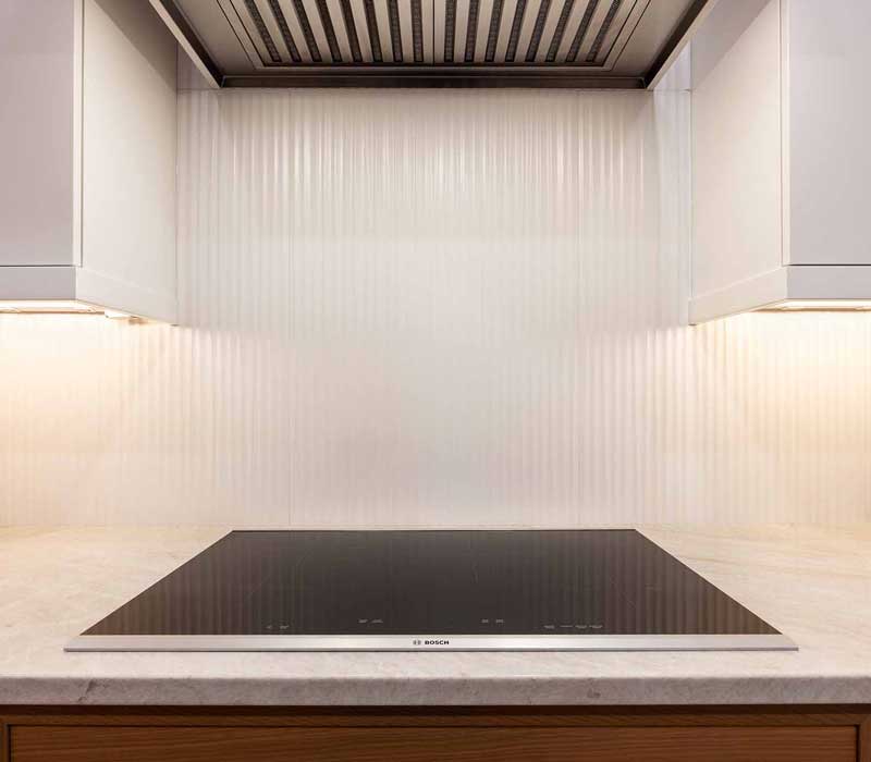 This full kitchen remodel blends natural warmth with refined modernity, crafting a space that is as inviting as it is impeccably tailored. It features custom DHDK cabinetry, Taj Majal quartzite, Bosch stainless steel appliances, and intuitive storage options.