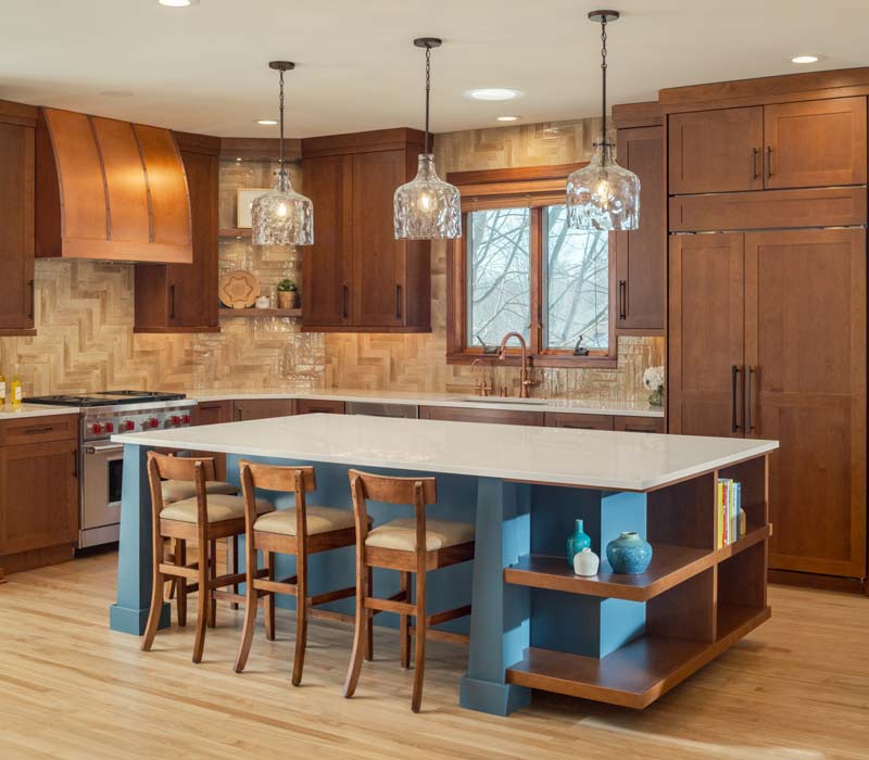 This whole-house remodel features a prairie-style kitchen adorned with custom cabinetry by DHDK, a primary suite with custom alder armoire, and bathroom with iridescent blue-green tiles.